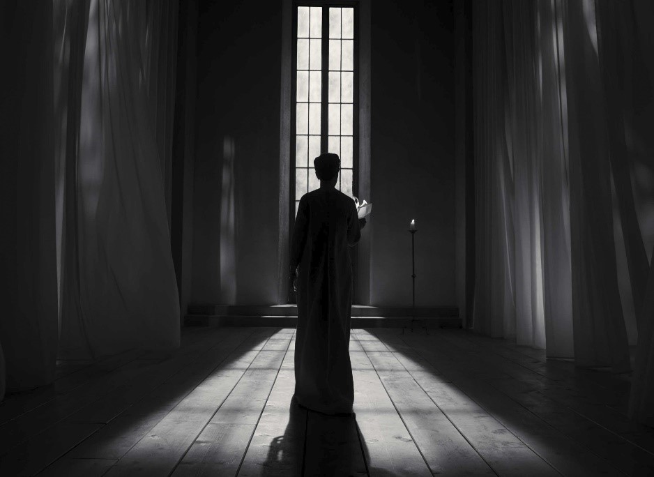 A person standing in a dark room
Description automatically generated with medium confidence
